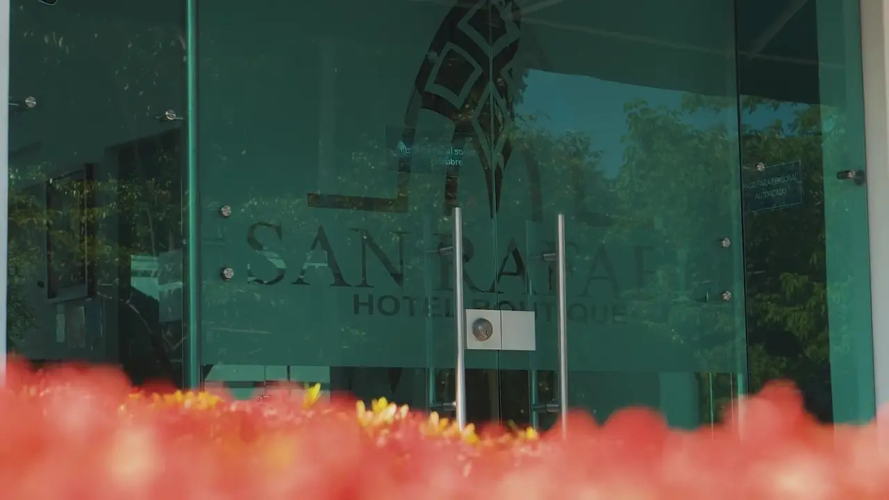Entrada del Hotel Boutique San Rafael entre flores y palmas